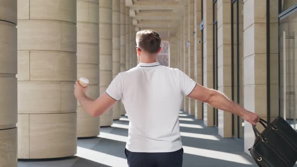 Crazy Young Businessman with Briefcase and Coffee Cup Dancing Outside Office Building