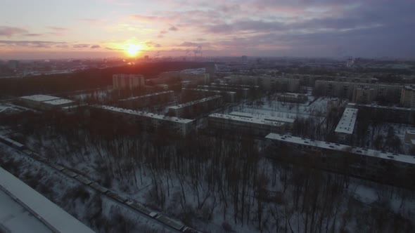 Flying over winter city and moving cargo train St Petersburg scene at sunrise
