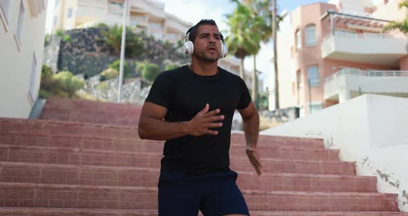 Man doing workout in the city while listening music