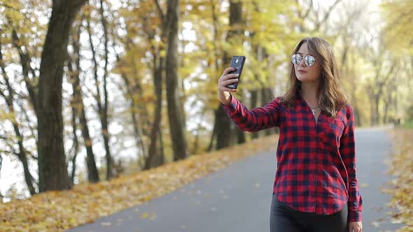 Beautiful brunette girl walks in the autumn park