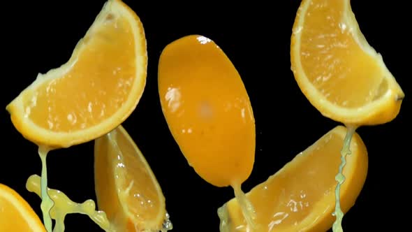 Thin Slices of Orange are Bouncing with the Splashes of the Orange Juice