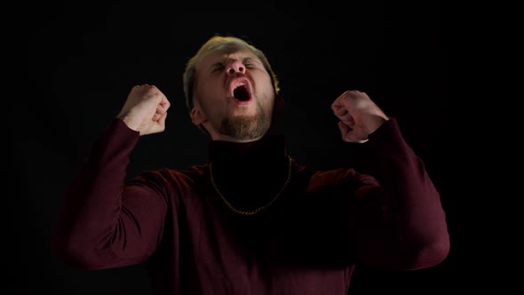 Overjoyed Young Man Wins Competition Achieves Goal and Makes Triumph Gesture Says Yes Shows Fist