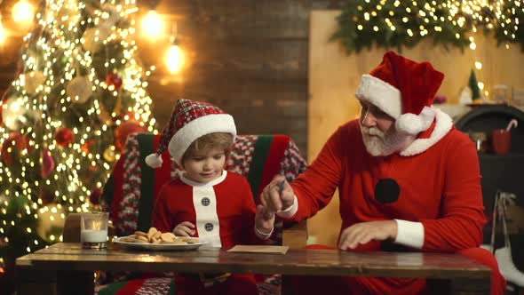 Grandfather and Child Writing Letter To Santa. Christmas Helper and Santa Reading Wish List Home