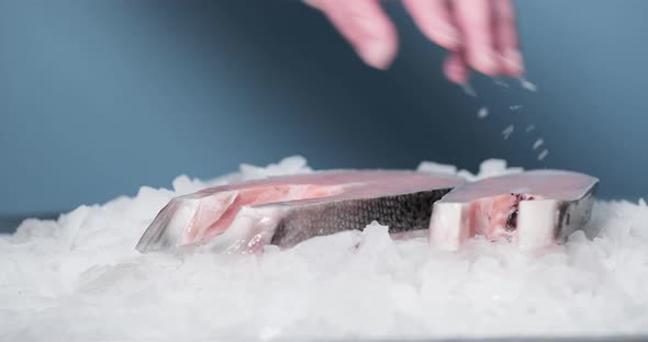 Fishmonger's Hand Puts Sliced Salmon On Top Of Ice - slow motion