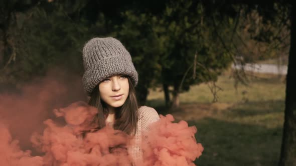 Portrait of Smart Girl Poses in Park with Colourful Fires