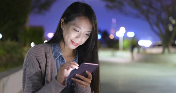 Woman use of smart phone at outdoor in winter time at night