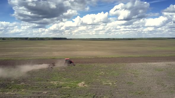 Bird Eye View Old Tractor Plows Large Empty Field in Dust