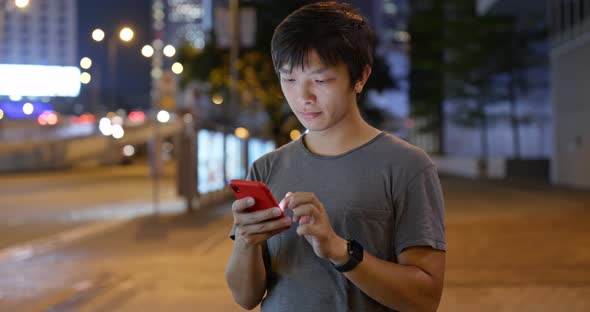 Asian man use of mobile phone in city at night