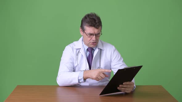 Mature Handsome Man Doctor Against Green Background