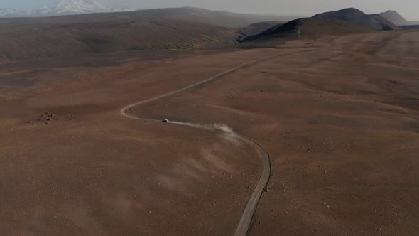 Establishing Shot Aerial View Car Driving Gravel Trail Path in Icelandic Dusty Desert