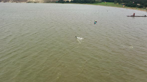 AERIAL: Drone view of People Engaged in Extreme Sports, Kitesurfing with Isolated Surfer in Focus