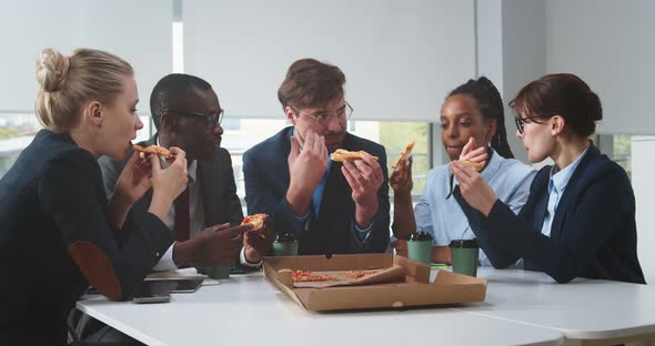 Young International Business Team Having Lunch Break in Office Eating Pizza Together