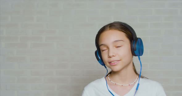 Teenage Girl in a Headphones Listening to the Calm Music