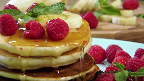 Pouring Honey on Stack of Pancakes