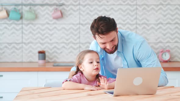 Smiling dad and little daughter talking on an online conference with mom using a laptop