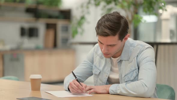 Pensive Creative Young Man Writing on Paper Thinking