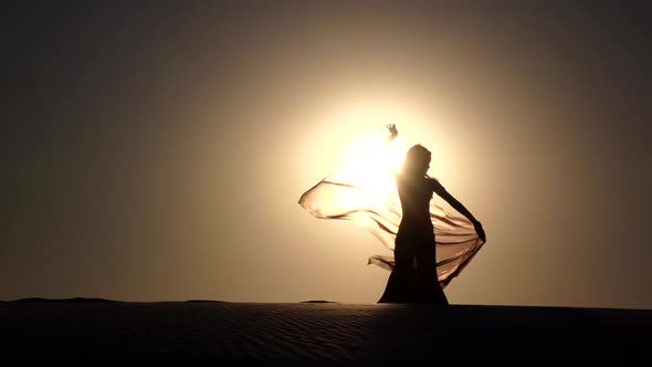 Girl on the Sunset Makes Graceful Movements. Slow Motion . Silhouette