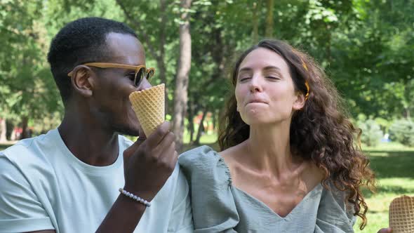 Black Man Treats His Girlfriend to Ice Cream in the Park While Sitting on the Lawn