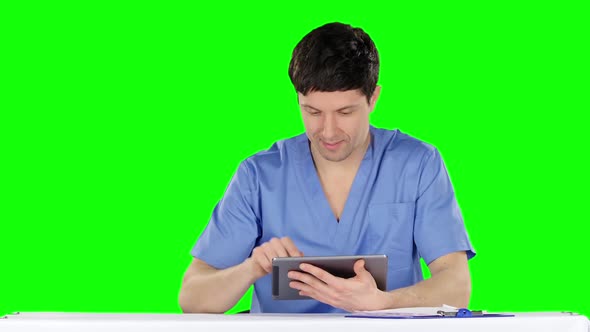 Smiling Doctor Using a Tablet. Green Screen