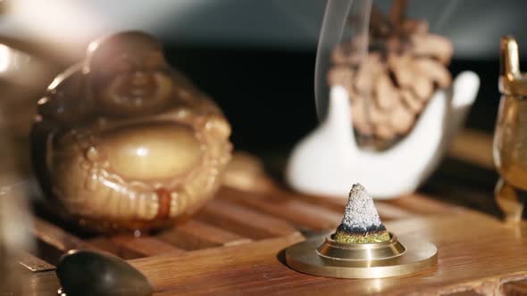 Pyramid From the Fragrant Juniper Smolders on the Background of the Tea Figurine