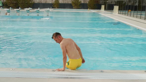 Man Sitting At Poolside