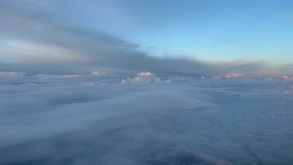 Aerial cockpit view, pilot pov, from a jet during cruise level at sunset, with nice dramatic clouds,