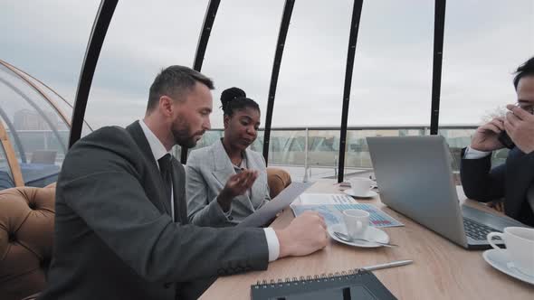 Colleagues Working in Rooftop Cafe