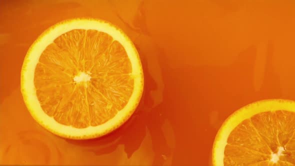 Fresh orange dropped into orange juice with splash