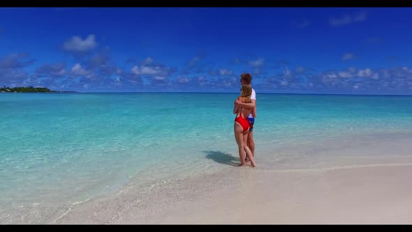 Two lovers tanning on marine resort beach lifestyle by turquoise sea and bright sandy background of 