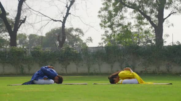 Padmasana with forward bend Yoga is being done by an Indian couple in an Indian outfit