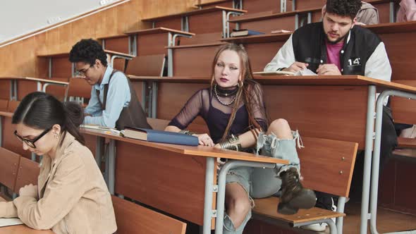 Gothic Female Student in Ripped Jeans in Classroom