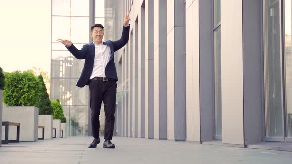 Cheerful happy asian business man dancing walk the corridor backdrop a modern office 