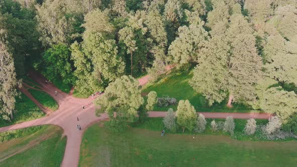 The Drone Flies Around Over Park in at Sunset in Park People Walk Children Families Footpaths Play