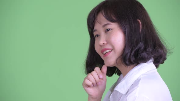 Closeup Profile View of Happy Beautiful Asian Businesswoman Thinking