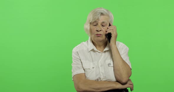 An Elderly Woman Talks on a Smartphone. Old Grandmother Smiles. Chroma Key