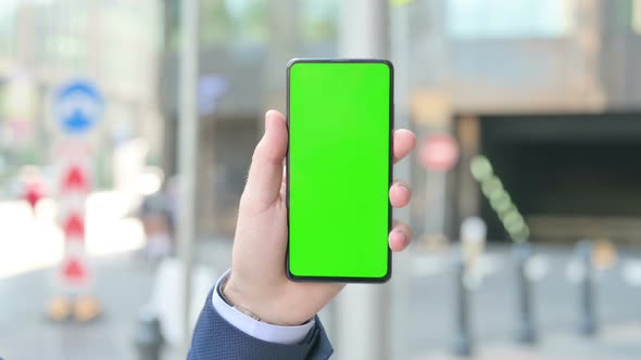 Businessman Holding Smartphone with Green Chroma Screen