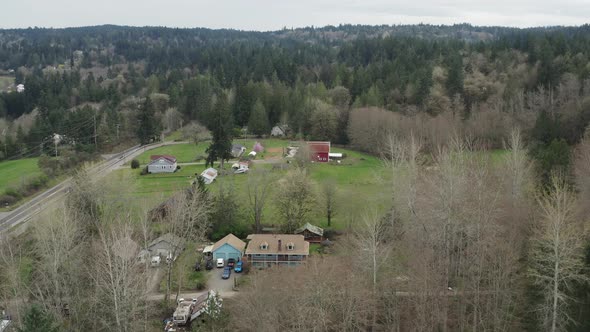 Farmhouse Surrounded By Dense Trees In Poulsbo, Washington State, USA. aerial pullback