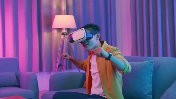 Young Asian Man Wearing Vr Headset And Dancing At Living Room, Cyan And Magenta Colors