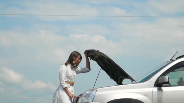 Woman Expresses Bewilderment When She Looks Under Hood of Car