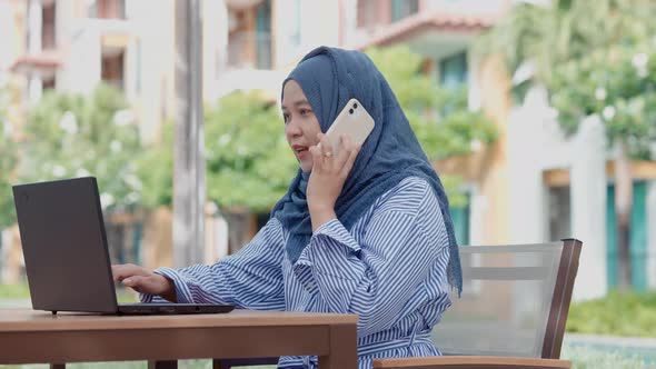 good looking Muslim women sitting outside working according to the slogan work form home