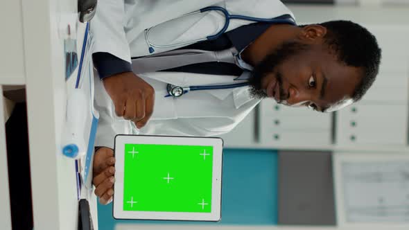 Vertical Video Male Obstetrician Showing Digital Tablet with Greenscreen