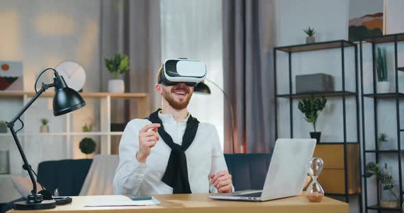 Man in Virtual Reality Headset Working on Imaginary Screen on the Beautifully Decorated home