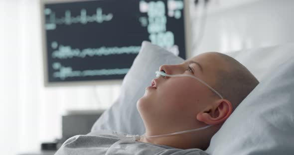 Sick Child with Cancer Lying in Hospital Bed with Nasal Cannula