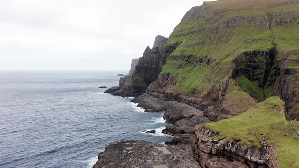 Aerial Back View of Huge Cliffs in Faroe Islands Green Rocky Mountainpowerful Ocean Wavesin a Cloudy