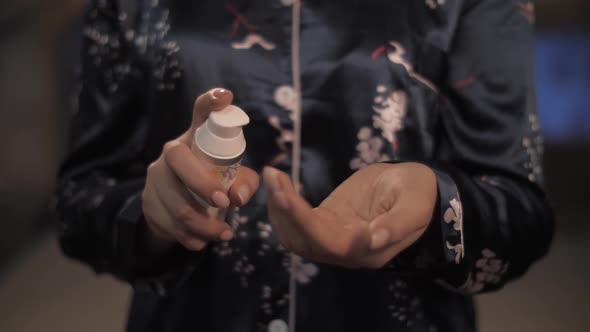 Beautiful Girl in Front of the Mirror Applies Moisturizer on Her Hand