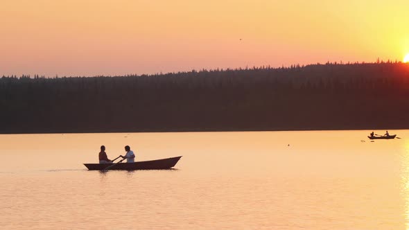 A Couple Having a Date - Sailing on the Boat Using Paddles - Beautiful Sunset