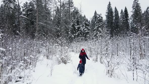 Boy and His Mother Run Through a Snowcovered Field