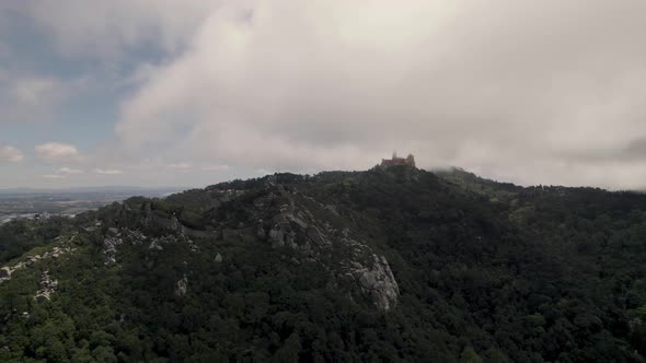 Hilltop Pena Palace against cloudy sky, Natural Park of Sintra, Portugal. Scenic aerial view