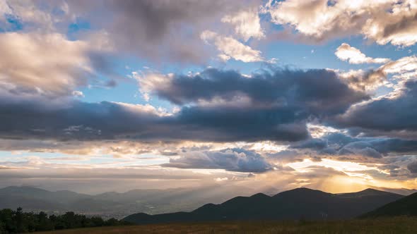 Time lapse: Sunset dramatic sky over Fabriano city, Marche, Italy. Sunbeams among clouds above uniqu