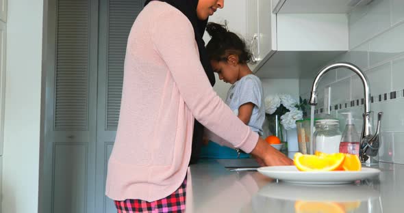 Young mother washing dishes in kitchen at home 4k